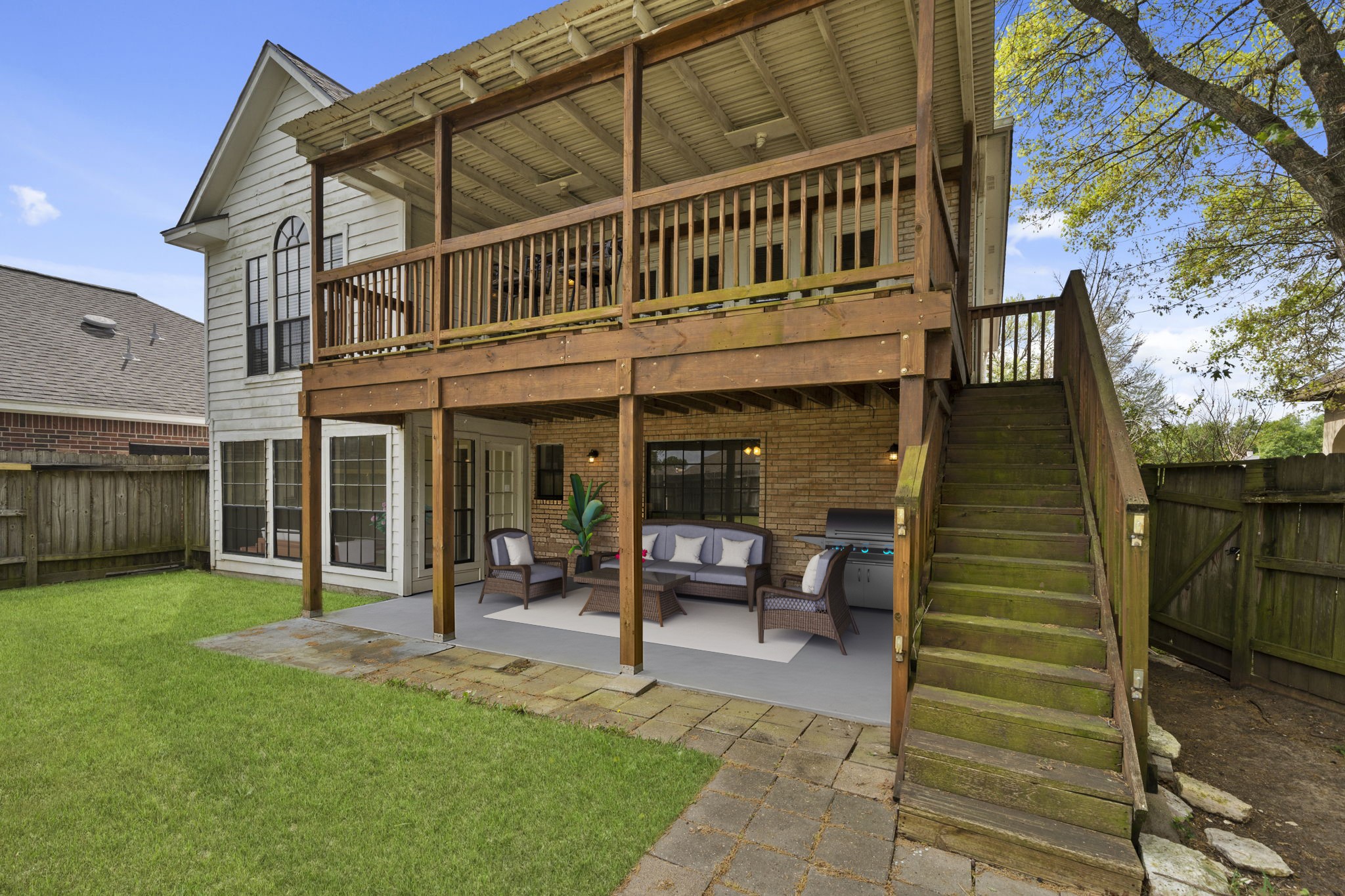 169 April Cove Montgomery, TX 77356 - Photo 30 of 39 Virtually Staged: Spacious backyard retreat featuring an elevated covered deck and a shaded patio below—perfect for outdoor entertaining.