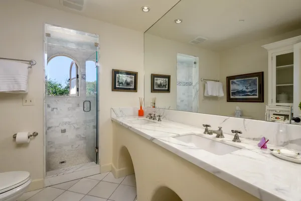 a bathroom with a granite countertop sink mirror and toilet