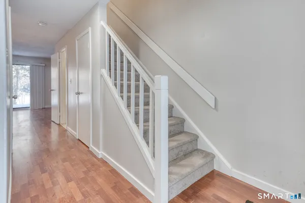 a view of staircase with wooden floor and white walls
