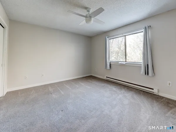 an empty room with a window and a ceiling fan