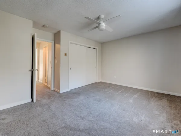 an empty room with a ceiling fan and a window