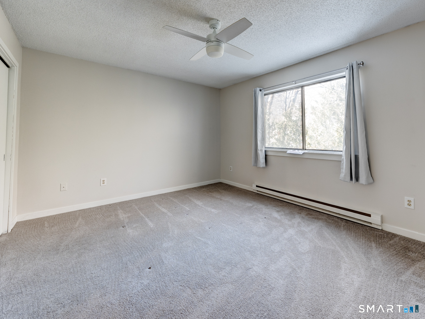 35 Riveredge Drive, Unit 35 Winsted, CT 06098 - Photo 21 of 33 an empty room with a window and a ceiling fan