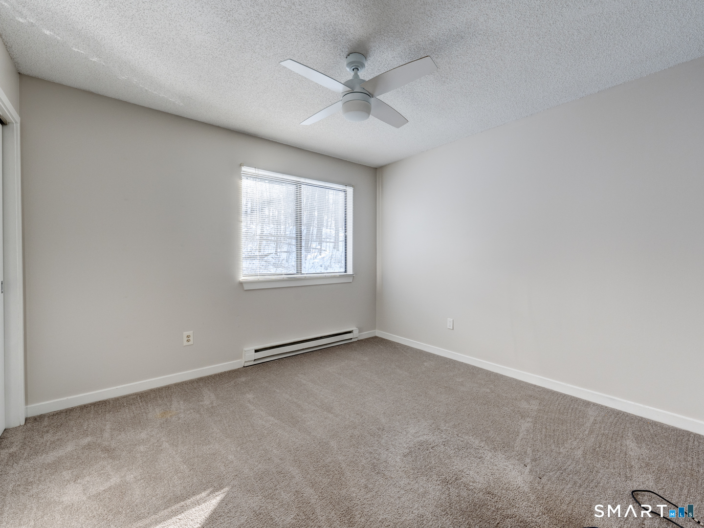 35 Riveredge Drive, Unit 35 Winsted, CT 06098 - Photo 27 of 33 an empty room with windows and ceiling fan