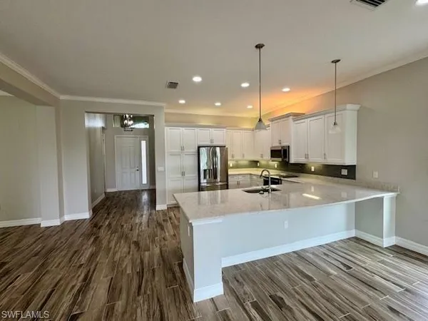 a large kitchen with kitchen island a sink stainless steel appliances and a counter top