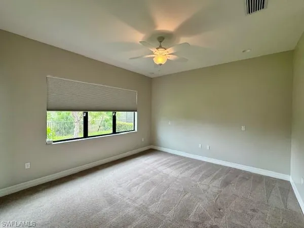 an empty room with a window and a fan