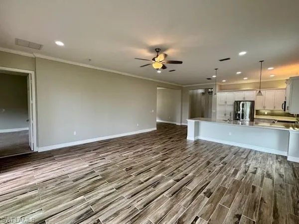 a view of an empty room with kitchen appliances and a couch