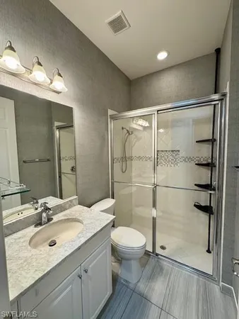 a bathroom with a double vanity sink toilet and shower