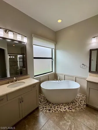 a spacious bathroom with a double vanity sink and a mirror
