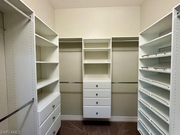 a view of walk in closet with empty racks