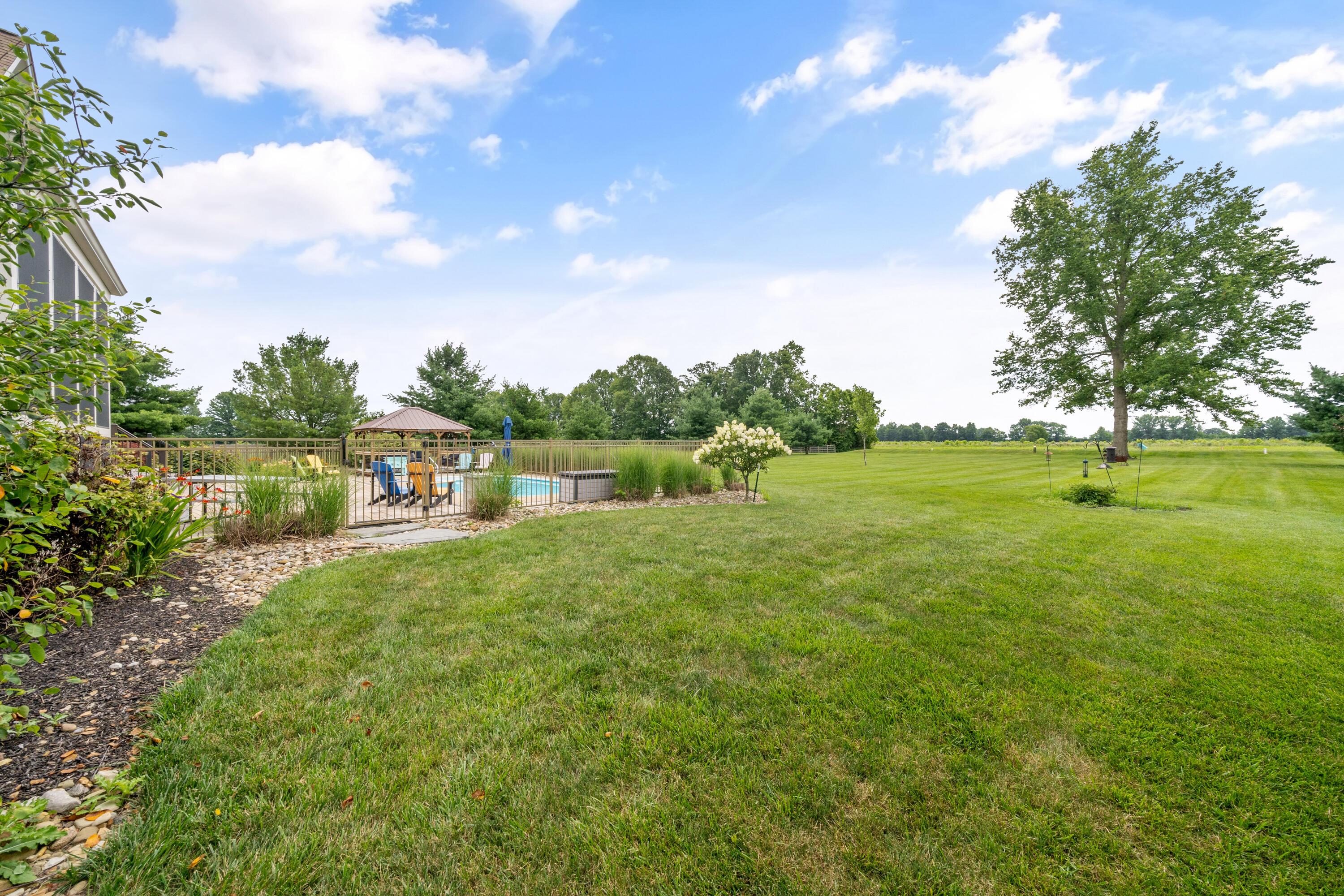 4640 Maynard Road Delaware, OH 43015 - Photo 79 of 91 Expansive exterior featuring a manicured lawn, a gated in-ground pool, a screened-in porch, and mature trees