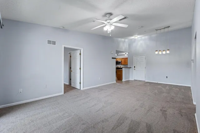 an empty room with an empty space and a ceiling fan