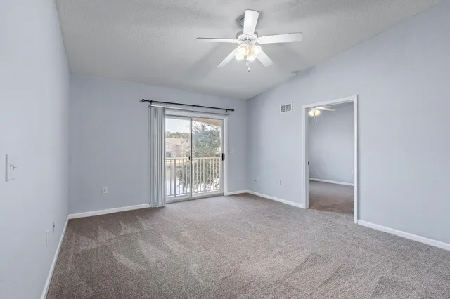 an empty room with chandelier fan