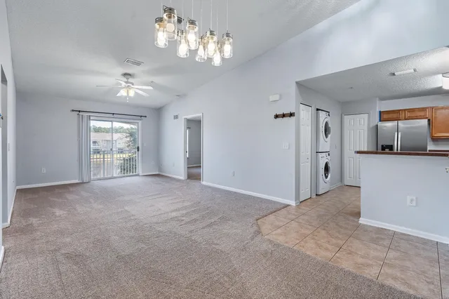 a view of a big room with windows and chandelier