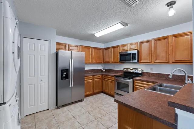 a kitchen with stainless steel appliances granite countertop a refrigerator stove microwave and sink