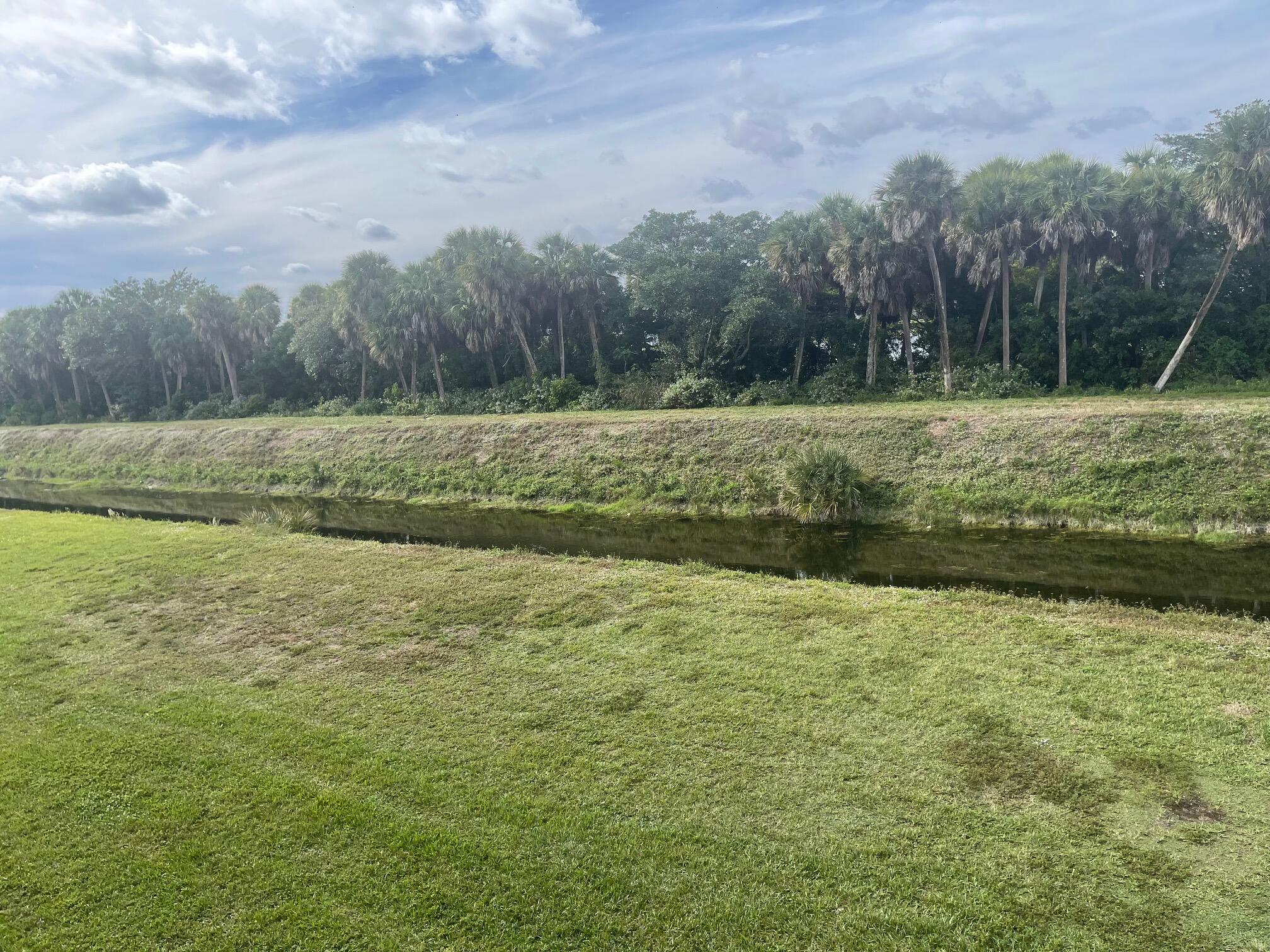 1089 Benoist Farms Road, Unit 207 West Palm Beach, FL 33411 - Photo 18 of 21 a view of a garden with trees