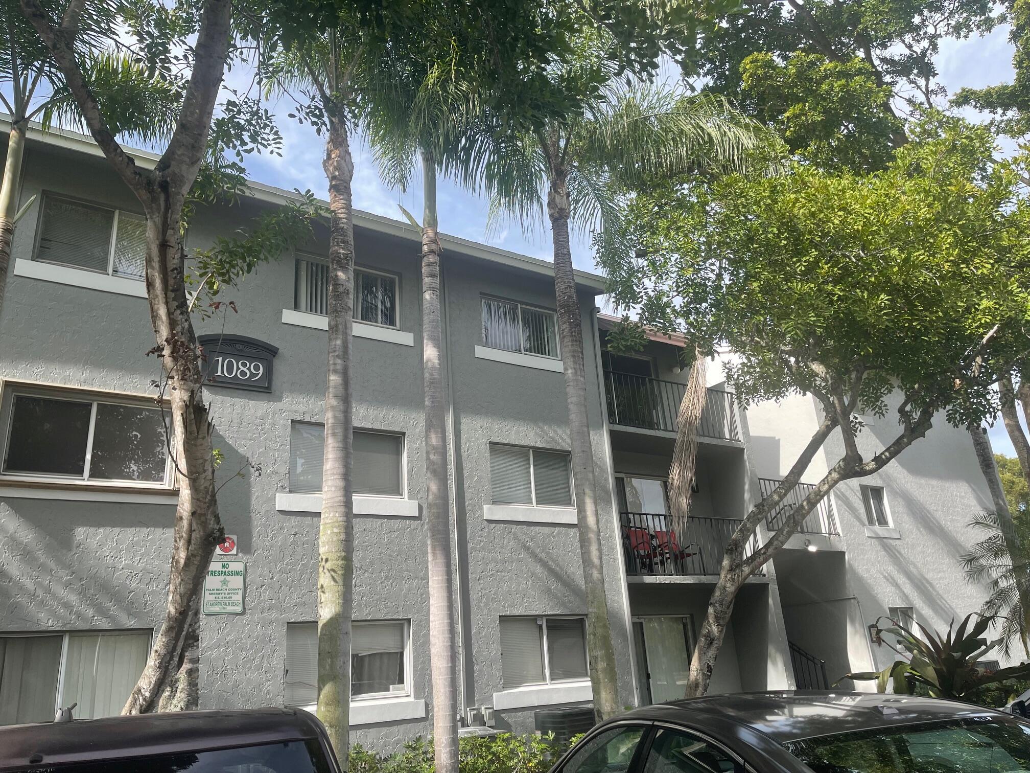 1089 Benoist Farms Road, Unit 207 West Palm Beach, FL 33411 - Photo 2 of 21 a front view of a house with a tree