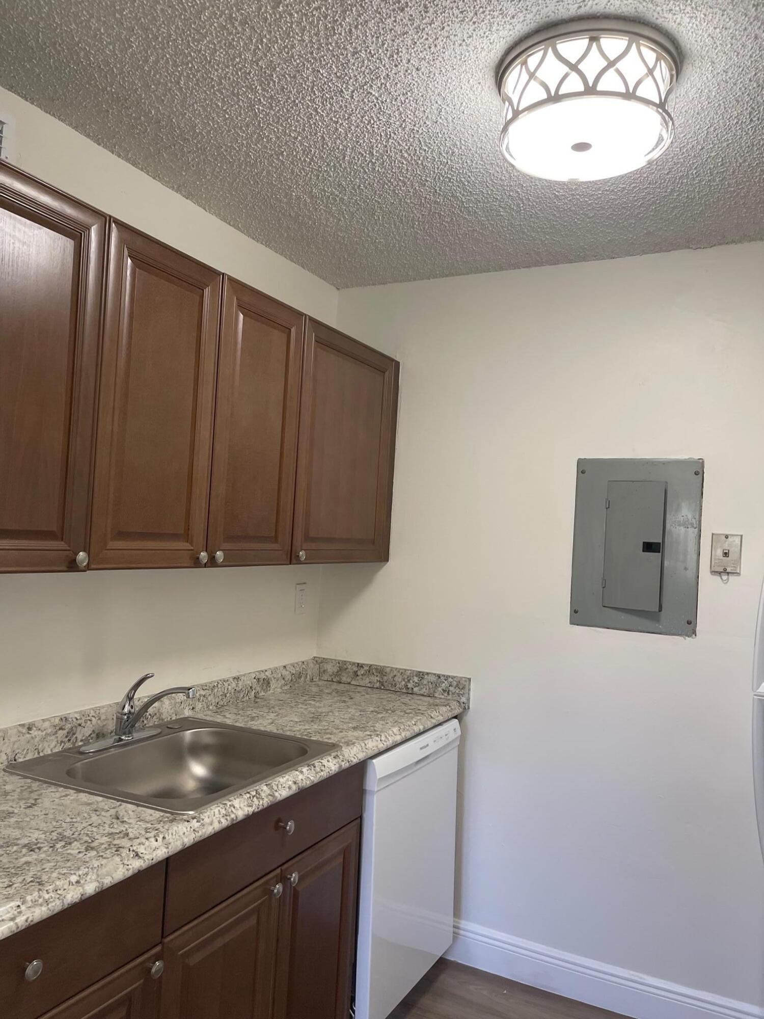 1089 Benoist Farms Road, Unit 207 West Palm Beach, FL 33411 - Photo 5 of 21 a kitchen with granite countertop cabinets and window