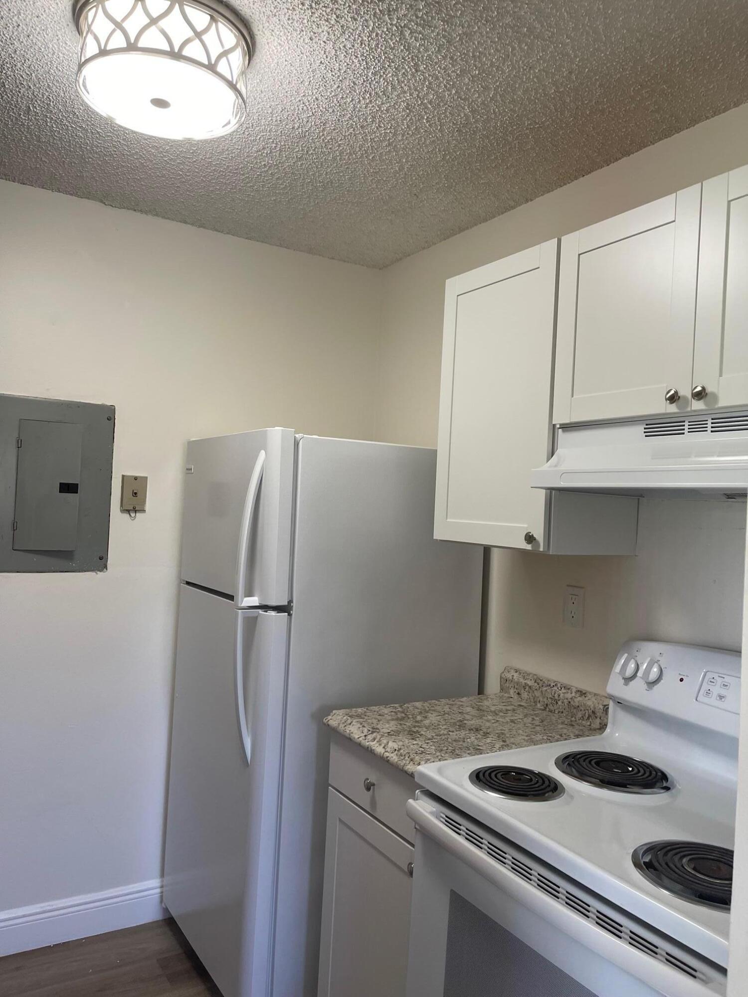 1089 Benoist Farms Road, Unit 207 West Palm Beach, FL 33411 - Photo 6 of 21 a kitchen with a refrigerator and a sink