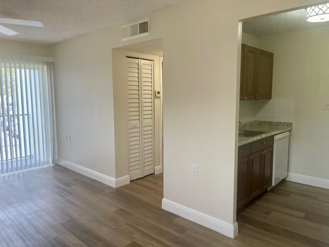 an empty room with wooden floor and entrance