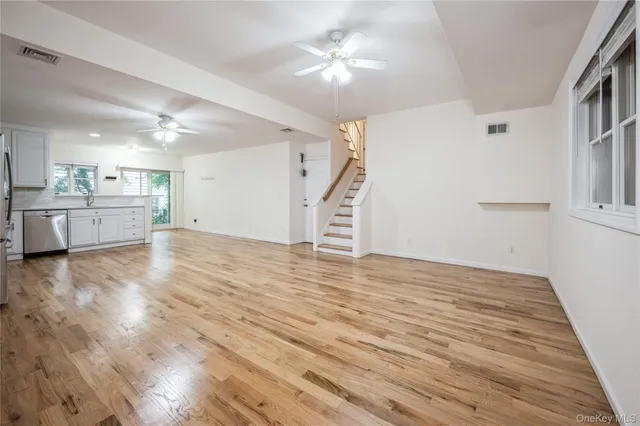 a view of a kitchen with wooden floor and a ceiling fan