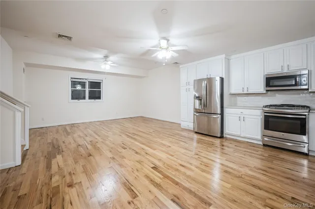 a kitchen with stainless steel appliances a refrigerator and a stove top oven