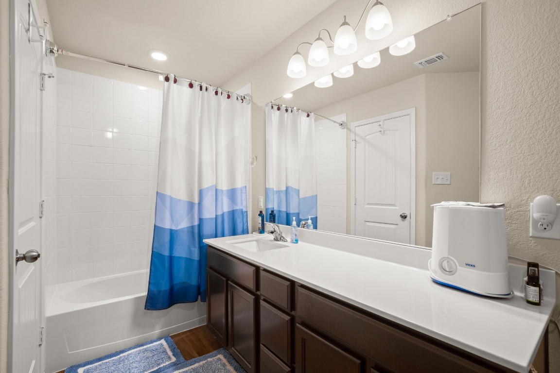 5526 Perdita Drive Belton, TX 76513 - Photo 18 of 23 a bathroom with a double vanity sink a mirror and a bathtub