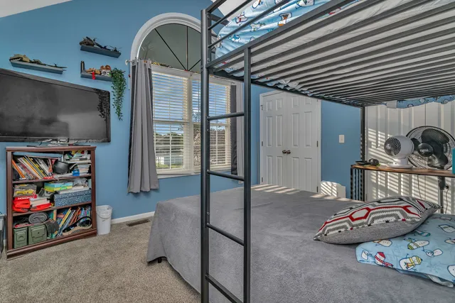 a bed sitting in a bedroom next to a window