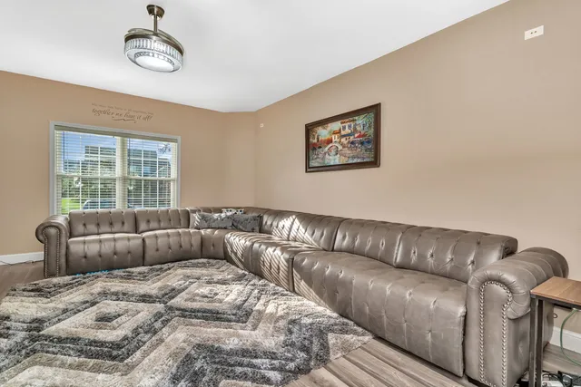 a living room with a couch wooden floor and window