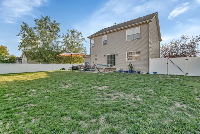 a view of a house with a yard and sitting area