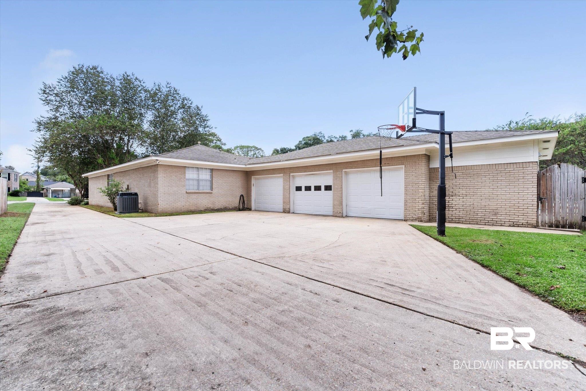 254 Woodlands Avenue Mobile, AL 36607 - Photo 36 of 50 View of home's exterior with concrete driveway, brick siding, and an attached garage