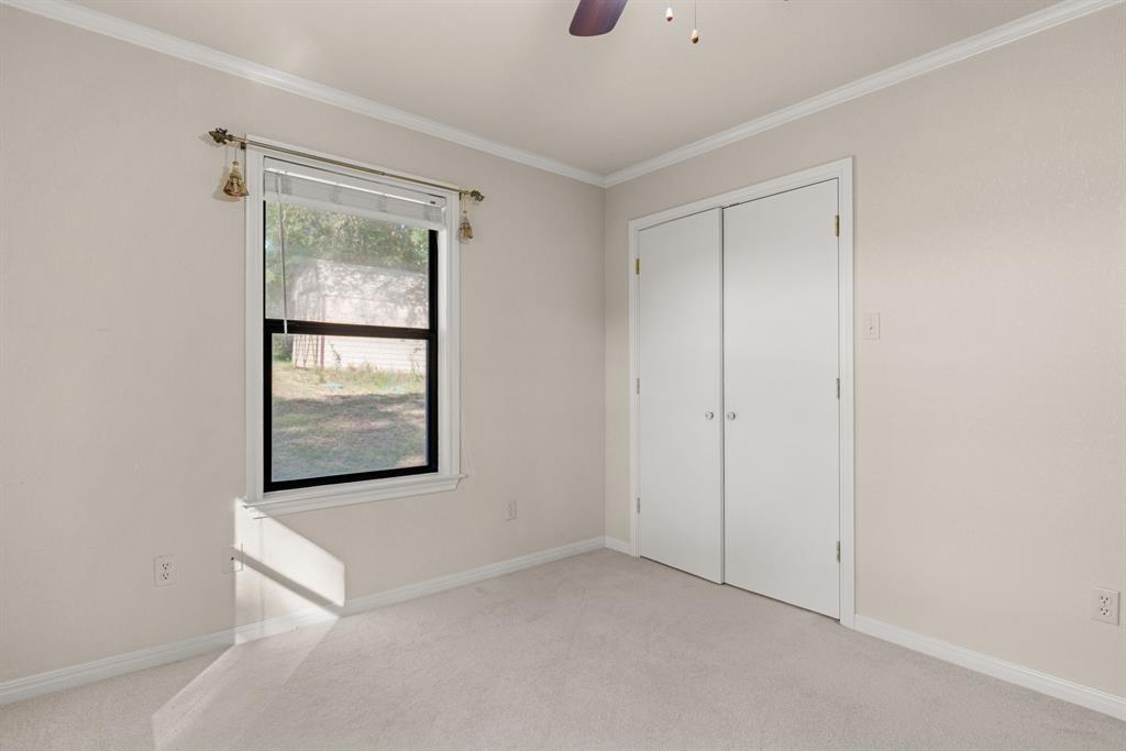 13539 Chapel Road Lorena, TX 76655 - Photo 25 of 37 Windowed room featuring light-colored walls, crown molding, and carpeted flooring
