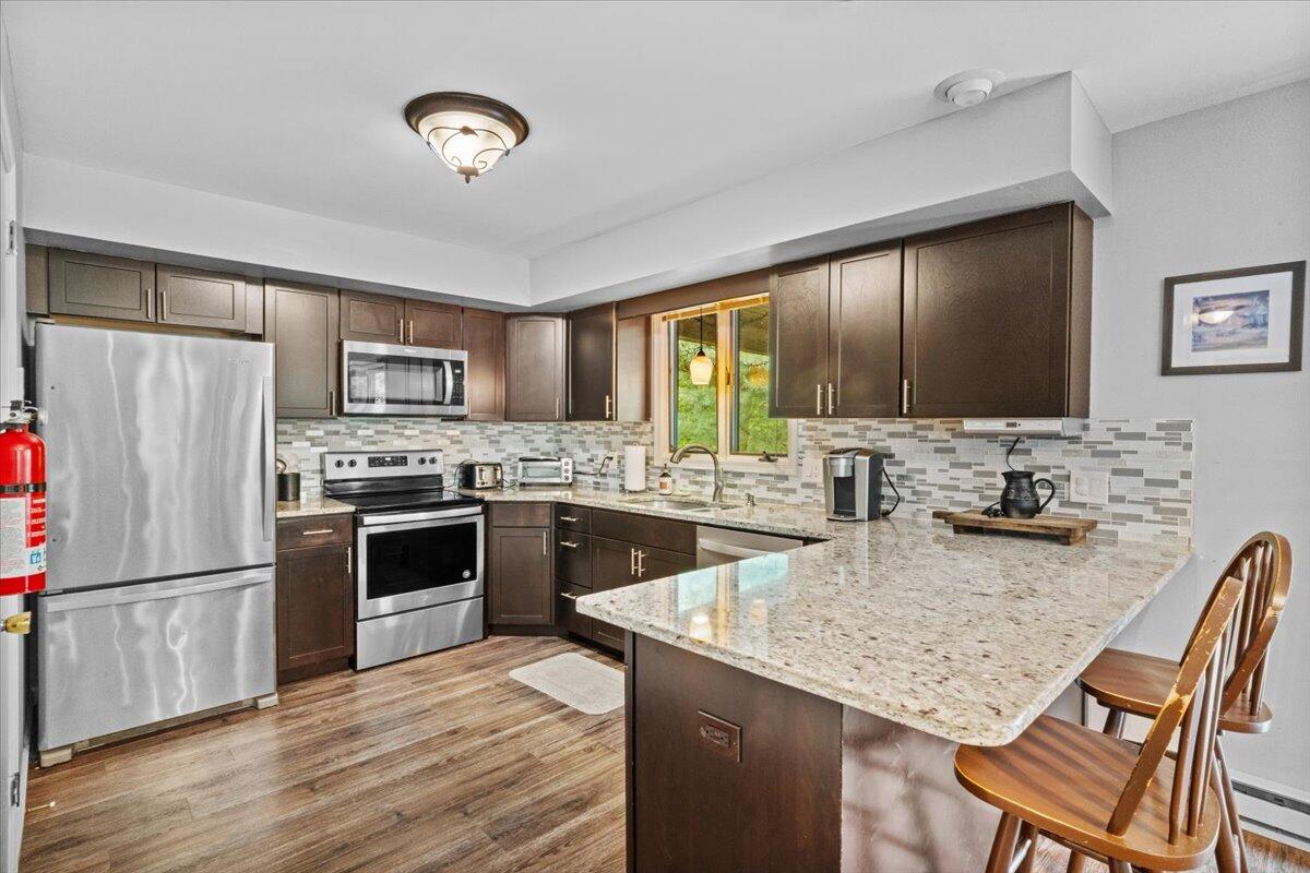 52 Hickory Road Lake Harmony, PA 18624 - Photo 11 of 36 a kitchen with a refrigerator stove a sink and dishwasher with wooden floor