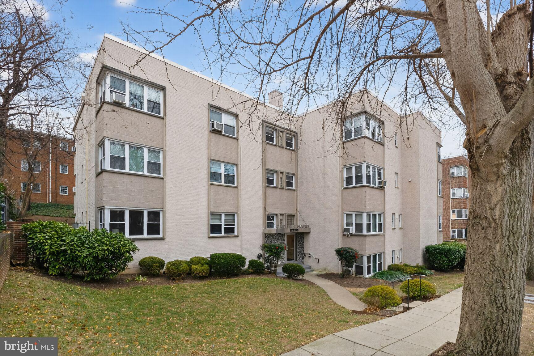 2339 40th Place Northwest, Unit 101 Washington, DC 20007 - Photo 1 of 12 a front view of a building with garden and trees