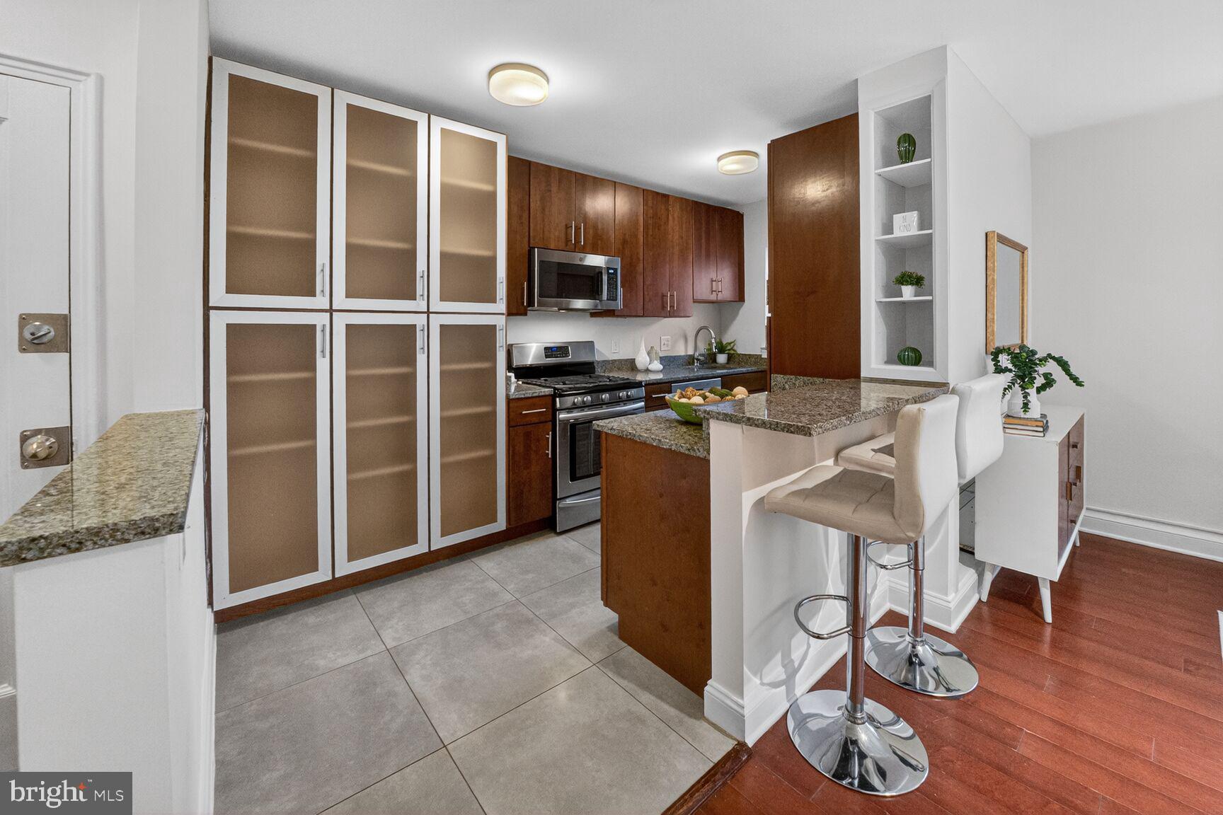 2339 40th Place Northwest, Unit 101 Washington, DC 20007 - Photo 8 of 12 a kitchen with stainless steel appliances granite countertop a stove top oven a sink and a granite counter tops