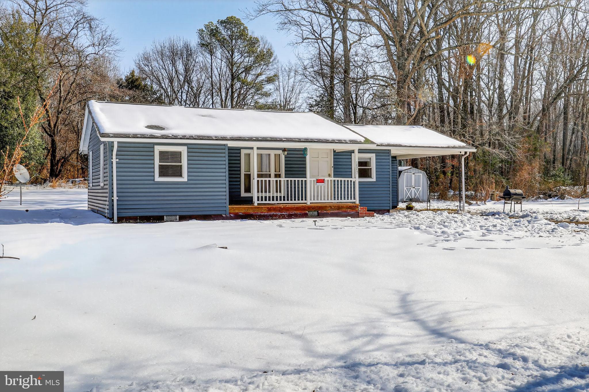 a front view of a house with a yard covered in snow
