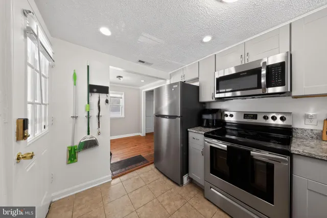 a kitchen with stainless steel appliances a stove microwave and refrigerator