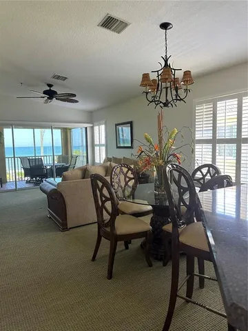a view of a livingroom and a dining room with furniture window and outside view