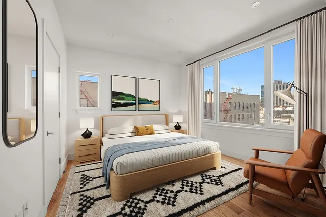 a bedroom with a bed a mirror on dresser and a window