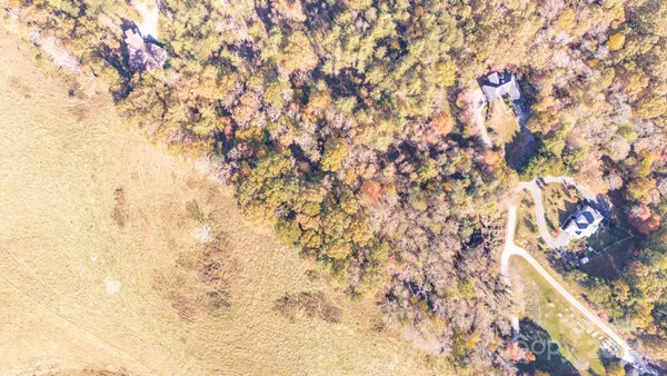 an aerial view of residential house with yard and mountain view in back