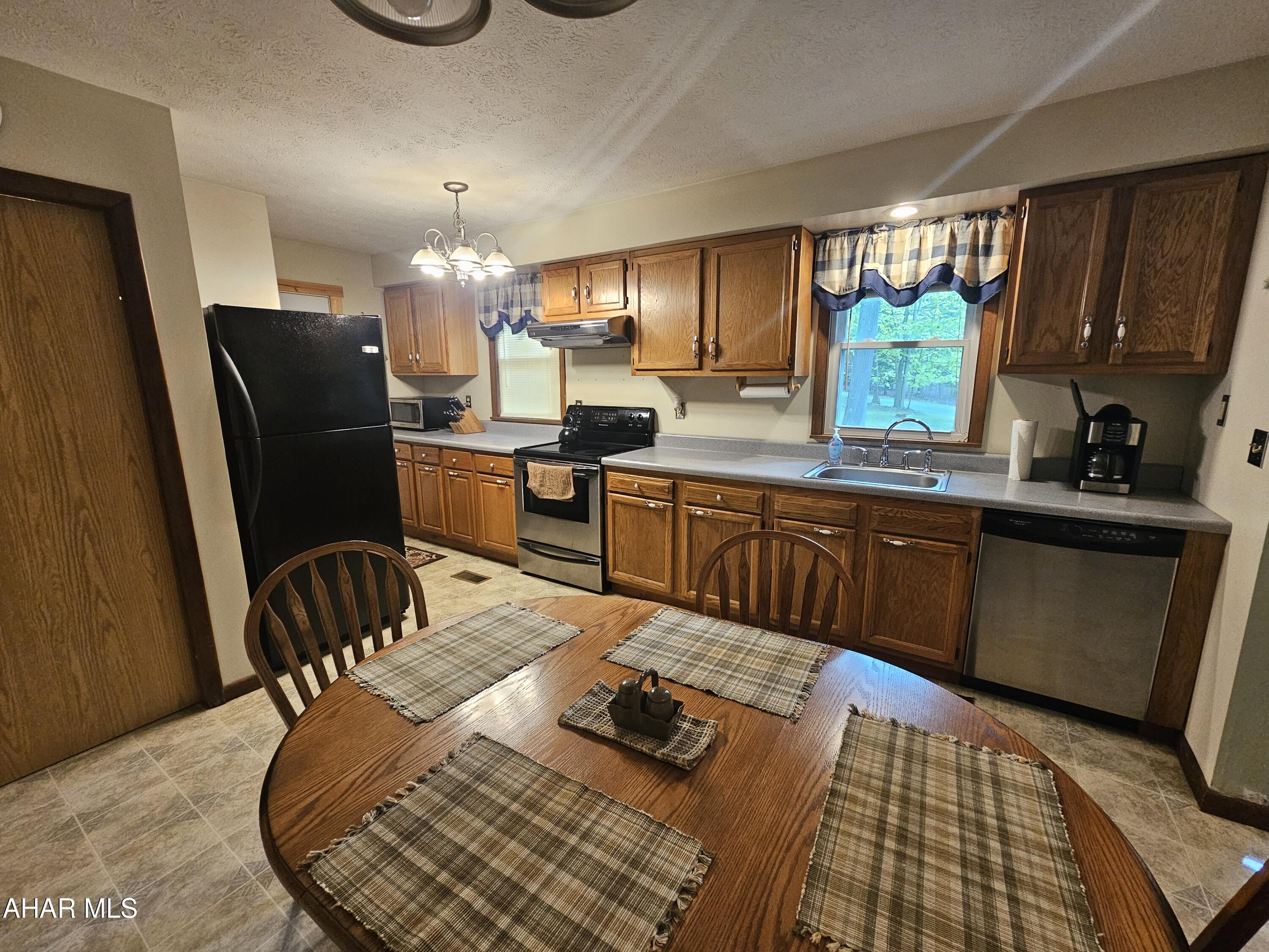 207 Kendrick Lane Flinton, PA 16640 - Photo 13 of 30 a kitchen with sink refrigerator dining table and chairs