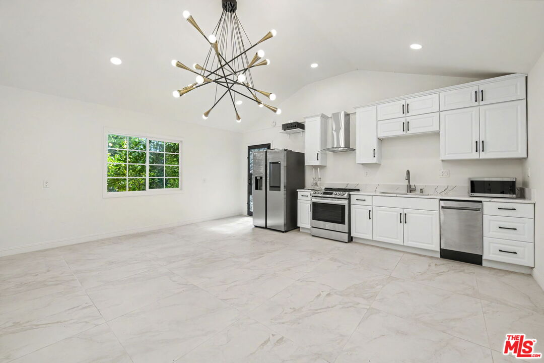 204 Foothill Road Beverly Hills, CA 90210 - Photo 37 of 38 a kitchen with stainless steel appliances kitchen island a white cabinets and window