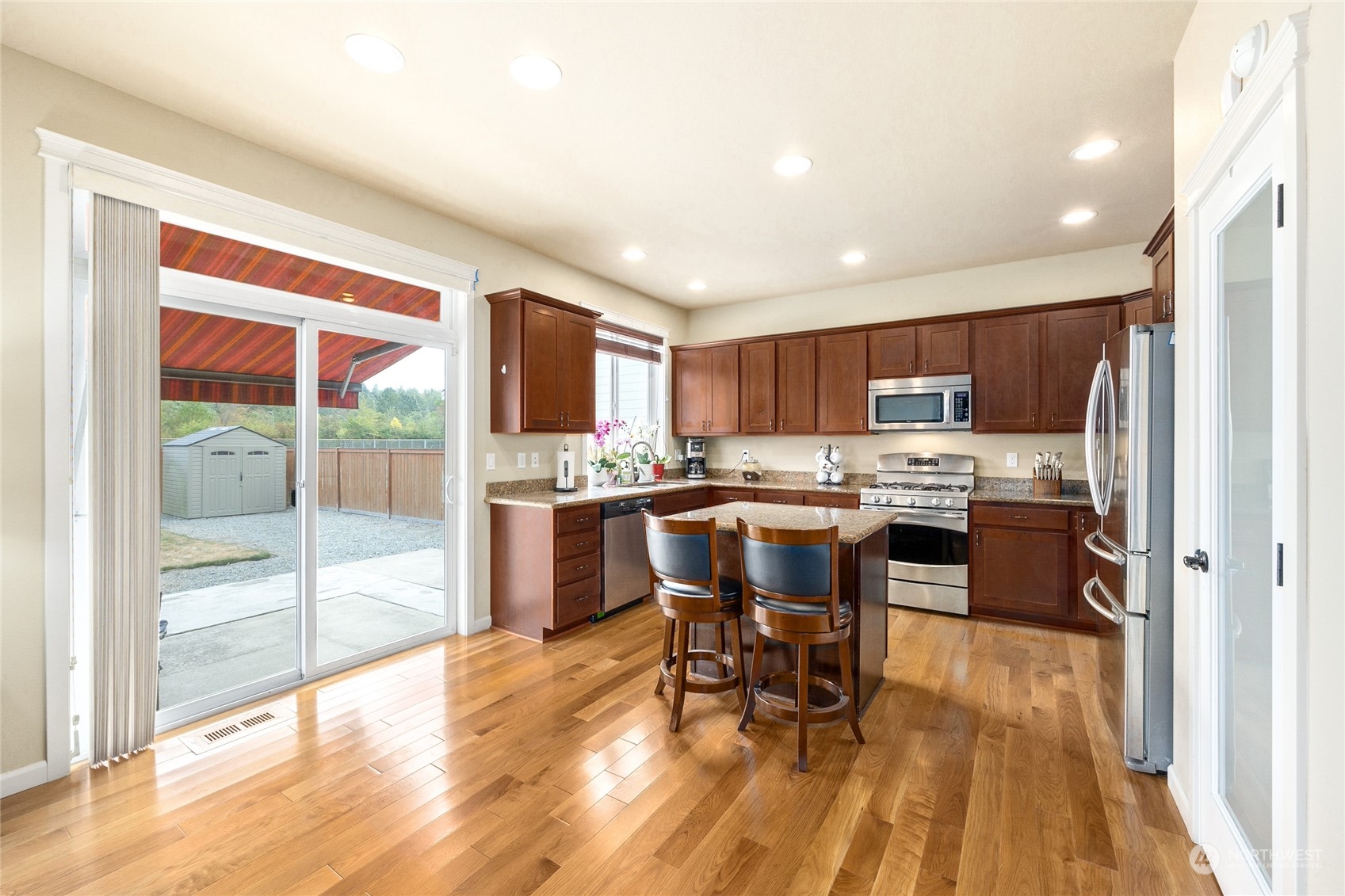 1910 Talbot Road South Renton, WA 98055 - Photo 7 of 26 a kitchen with stainless steel appliances kitchen island granite countertop a refrigerator and a stove top oven