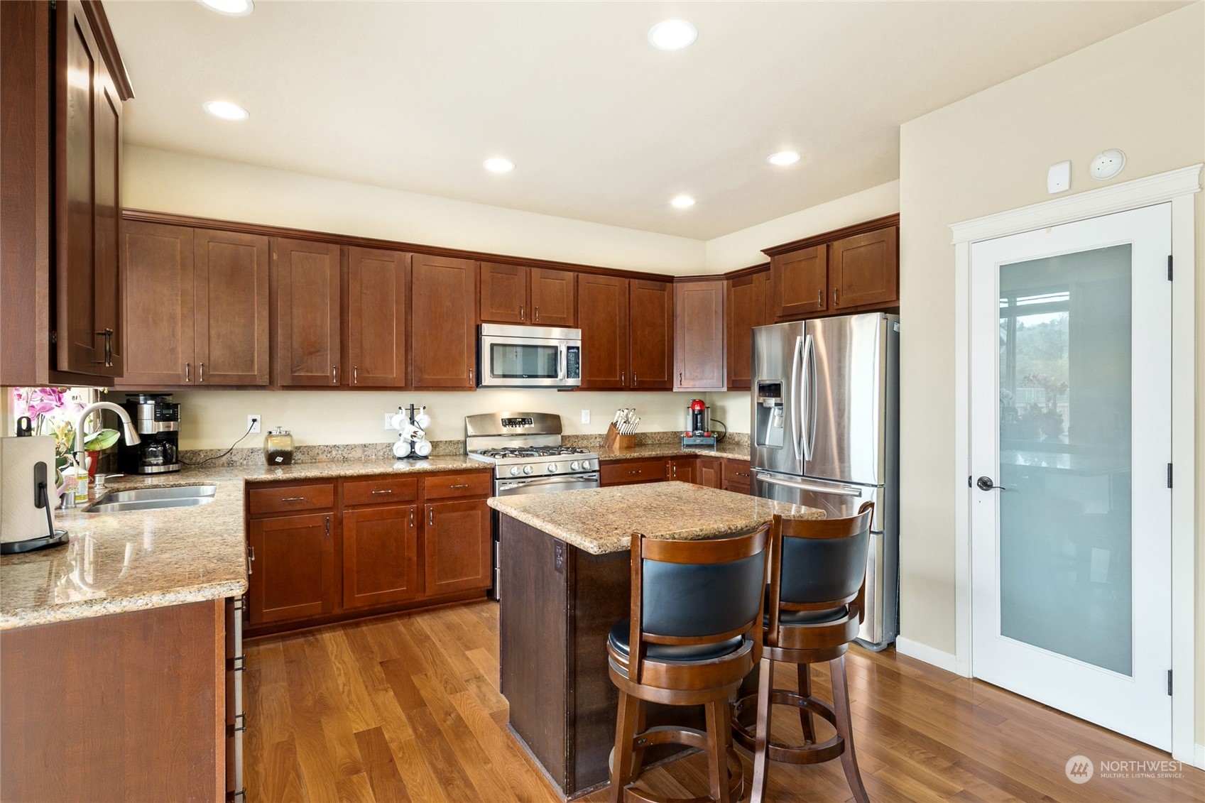 1910 Talbot Road South Renton, WA 98055 - Photo 8 of 26 a kitchen with stainless steel appliances granite countertop a refrigerator a sink a stove a dining table and chairs
