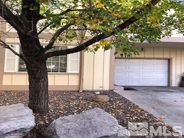 a front view of a house with a tree