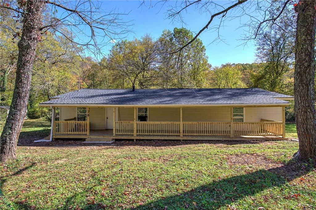 a view of a house with a yard and wooden fence
