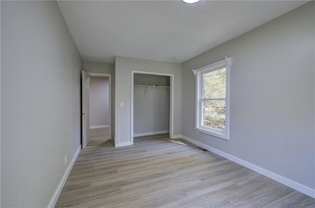 76 Morning Dew Lane Clayton, GA 30525 - Photo 12 of 28 an empty room with wooden floor and windows
