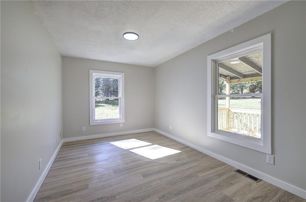 76 Morning Dew Lane Clayton, GA 30525 - Photo 16 of 28 an empty room with wooden floor and windows