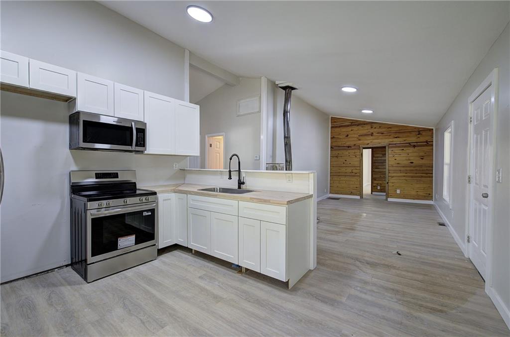 76 Morning Dew Lane Clayton, GA 30525 - Photo 2 of 28 a kitchen with stainless steel appliances granite countertop a stove a sink and a refrigerator