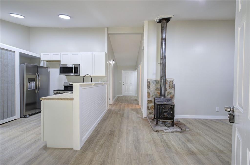 76 Morning Dew Lane Clayton, GA 30525 - Photo 22 of 28 a view of a kitchen with refrigerator and wooden floor