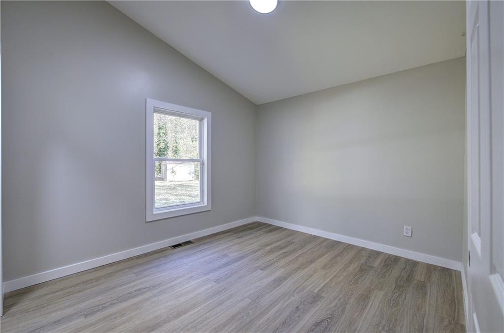 76 Morning Dew Lane Clayton, GA 30525 - Photo 7 of 28 an empty room with wooden floor and windows